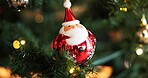 Christmas, festive and wallpaper with Santa on tree in home for celebration, event or tradition. Background, decoration and holiday with ornament in apartment for aesthetic, vacation or winter season