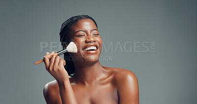 Buy stock photo Makeup, beauty and black woman laugh with brush in studio for shine, foundation or glow. Funny, apply cosmetics and model with product for facial makeover, change and powder on gray background space