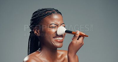 Buy stock photo Makeup, beauty and happy black woman with brush in studio for shine, foundation or glow. Smile, apply cosmetics and model with product for facial makeover, change and powder on gray background space