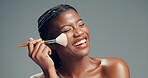 Black woman, brush and happy in studio for makeup, contouring and confident with beauty. Female person, cosmetology and blush tool on gray background for blending, cosmetic application or laughing