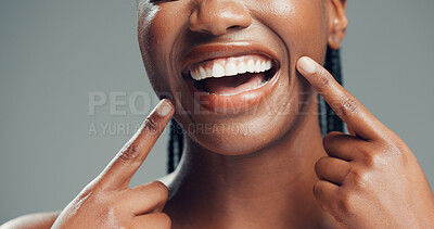 Buy stock photo Teeth, dental wellness and woman point at mouth for oral health, fresh breath and gum care. Hands, excited person and tooth whitening for orthodontics, veneers or lips in studio on gray background