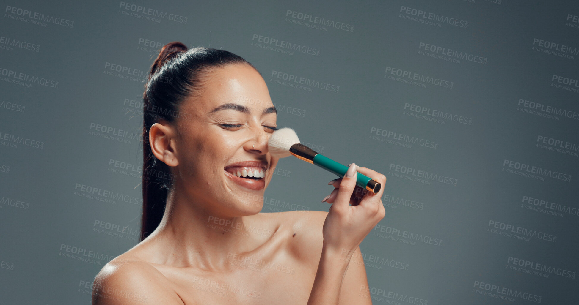 Buy stock photo Woman, brush and laugh in studio for makeup, contouring and tickle nose with beauty. Person, cosmetics and blush tool on gray background space for blending, application and excited with manicure
