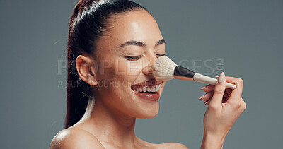 Buy stock photo Woman, brush and happy in studio for makeup, contouring and tickle nose with beauty. Person, cosmetology and blush tool on gray background for blending, cosmetic application and smile with manicure