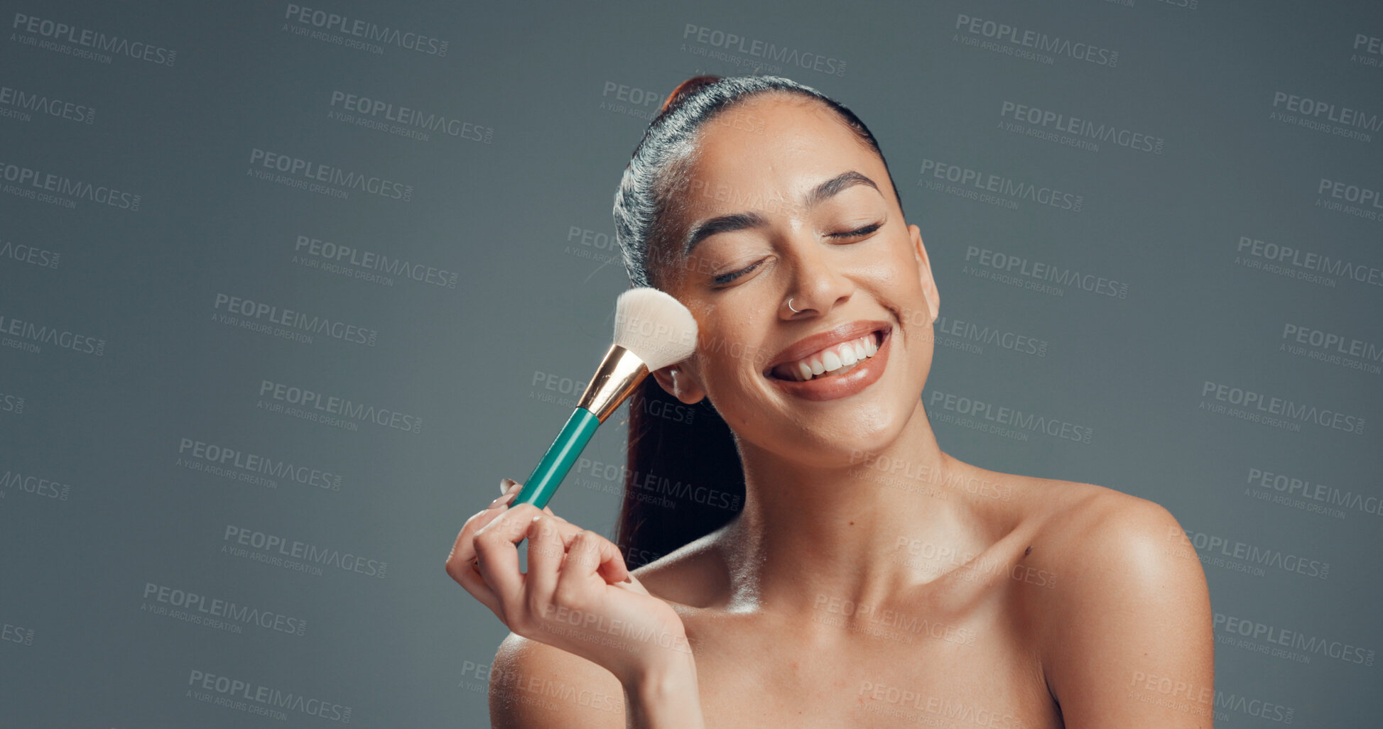 Buy stock photo Makeup, brush and and woman in studio for cosmetics, contouring and beauty treatment. Happy, blush and female person with tool for blending, application and cosmetology routine by gray background.