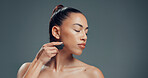 Skincare, space or woman in studio with gua sha, facial benefits or massage in self care. Cosmetology, jaw tone and girl on gray background with tool, sculpting or lymphatic drainage for firm skin.