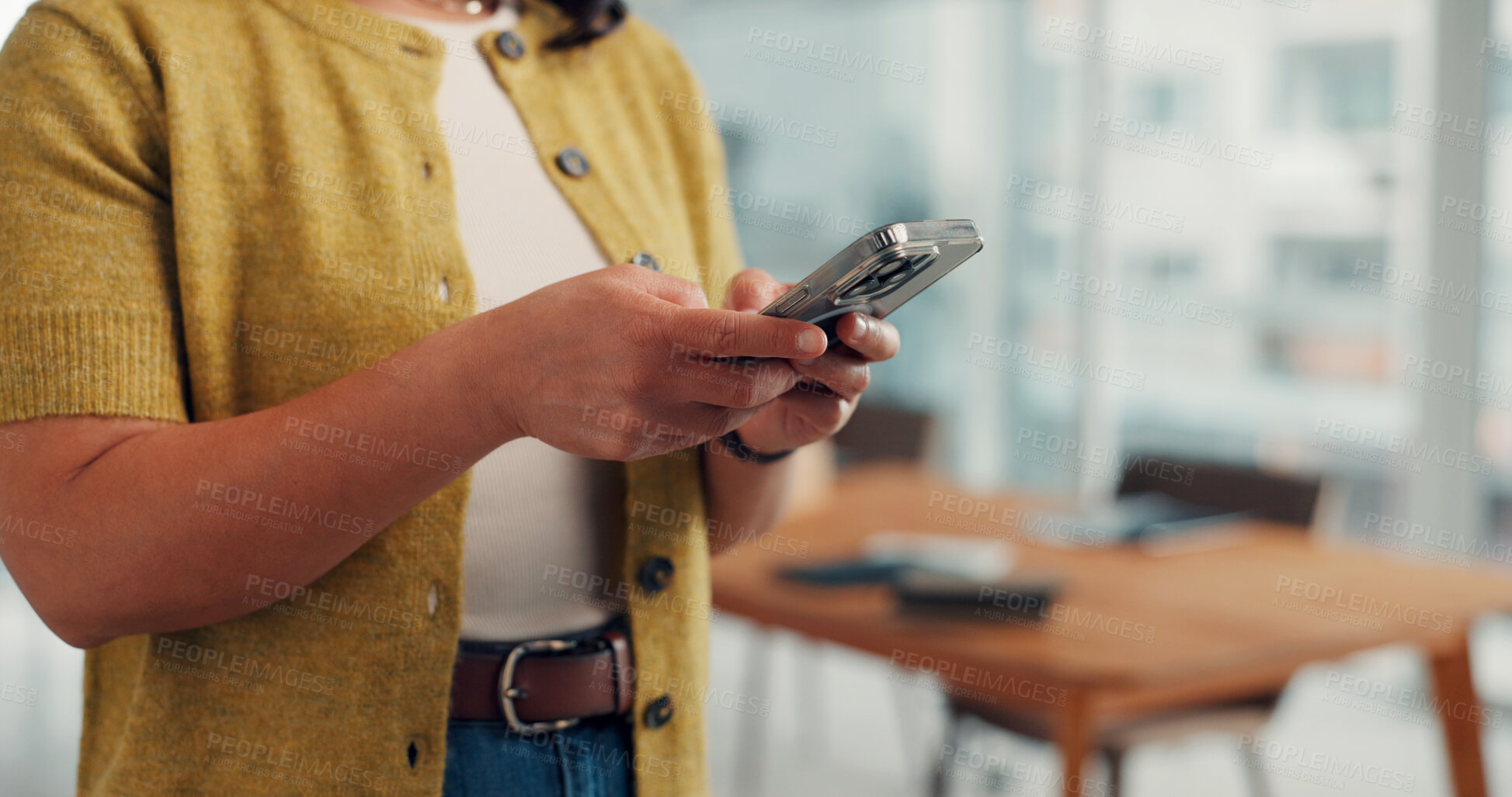 Buy stock photo Hands, phone and texting in office at startup, contact and notification for deal at media company. Person, smartphone and scroll with mobile app, chat or social network management at creative agency