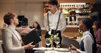 Buy stock photo Waiter, couple and talk at restaurant with menu, decision and discussion for wine list, food or order. People, server and customer experience with service, question and opinion for choice at dinner
