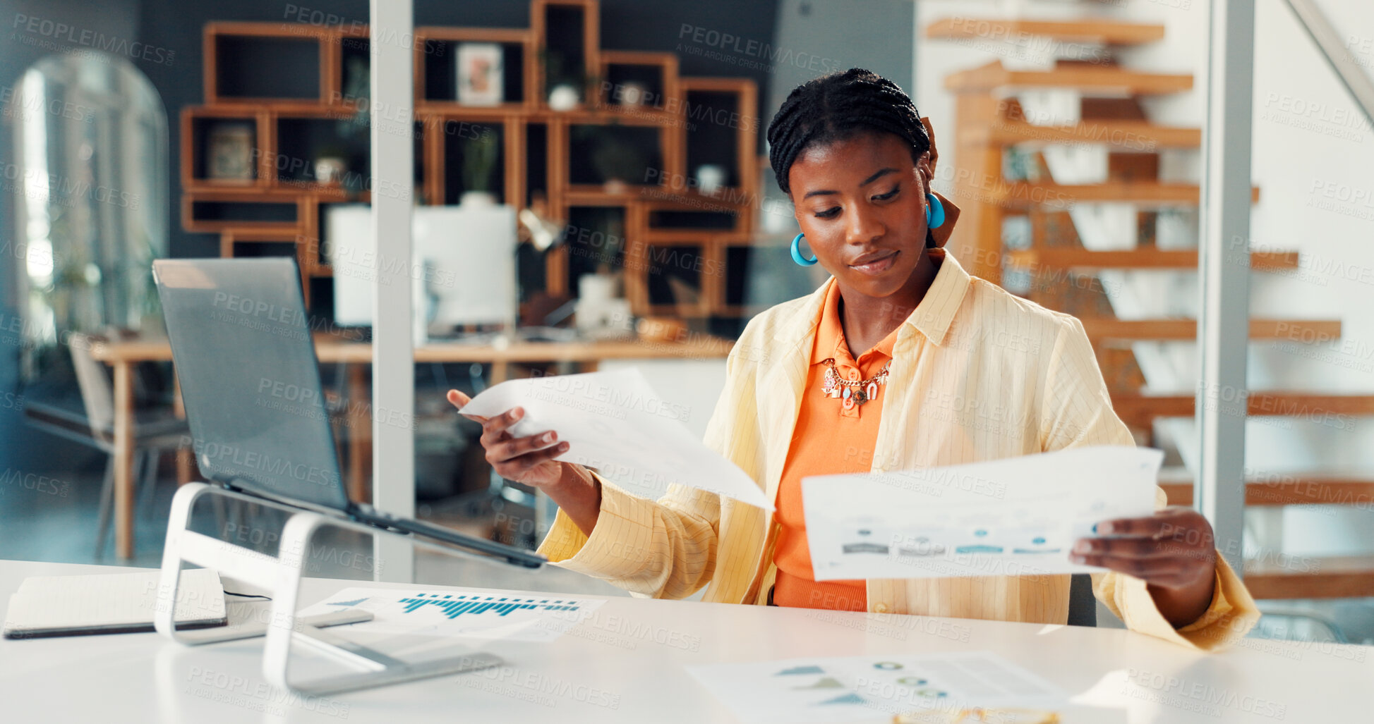 Buy stock photo Black woman, reading and documents at house for accounting, finance report and statistics. Person, remote work and laptop with paperwork, revenue graphs and financial comparison for audit information