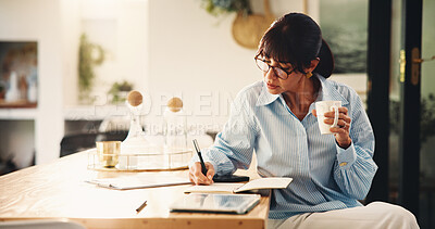 Buy stock photo Woman, writing and notebook with coffee at house for planning, finance reminder and payment timeline. Mature person, beverage and notes of household budget, tracking expenses and financial management