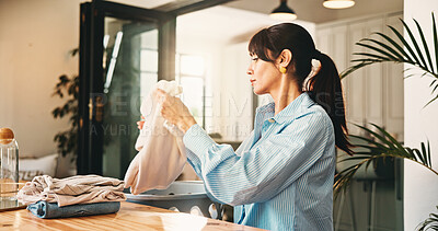 Buy stock photo Woman, fold laundry and basket in home, hygiene and routine with garment, chores and packing in morning. Mature person, container and domestic task with clean clothes, fabric or sanitation at house