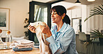 Woman, smell and fold clothes in home with hygiene, scent and happy with routine for chores. Mature person, laundry and fabric with fragrance, cleaning and inspection with sanitation at apartment