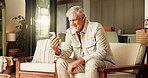 Senior man, phone and reading on sofa with laughing, smile or funny article on website in living room. Elderly person, smartphone and happy with scroll, search and mobile network with app in home