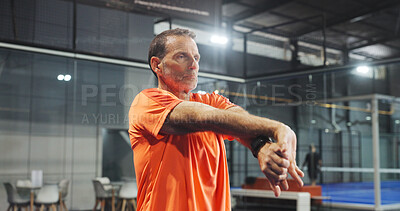 Buy stock photo Fitness, padel and mature man stretching on court for match preparation, start practice and workout. Exercise, person and serious with arm warm up at indoor tennis club for sport performance and game
