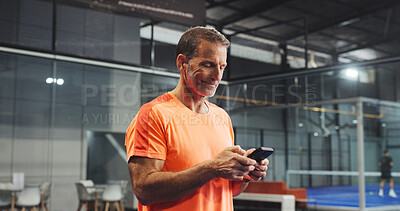 Buy stock photo Sport, practice and man with phone on court for padel training schedule, text message or break. Tennis player, mature person and happy with smartphone at indoor club for fitness app and track score