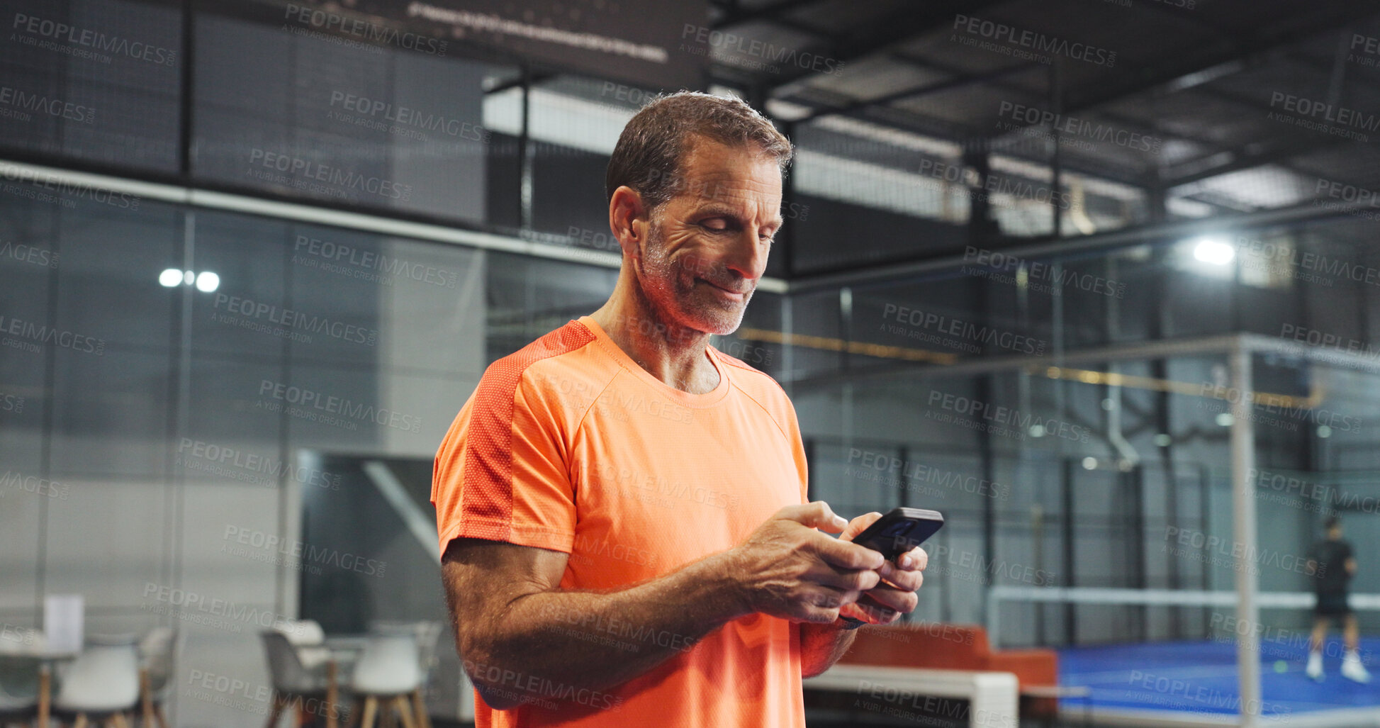 Buy stock photo Sport, practice and man with phone on court for padel training schedule, text message or break. Tennis player, mature person and happy with smartphone at indoor club for fitness app and track score
