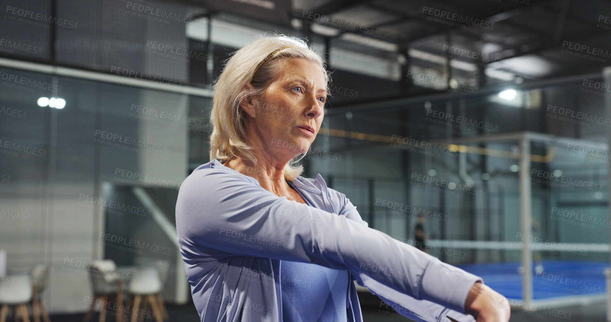 Buy stock photo Padel, exercise and mature woman on court stretching to prepare for game, match and competition. Indoor, sports and person warm up for fitness, workout and training for practice, health and tennis