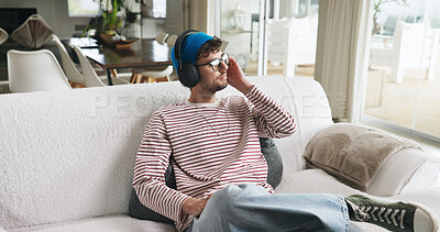 Buy stock photo Home, headphones and man on couch, thinking and listening to music, sound and podcast. Apartment, relax and person on sofa, audio and radio with contemplation, daydreaming or playlist album in lounge