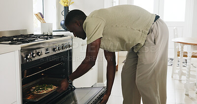 Buy stock photo Cooking, pizza and recipe with black man in kitchen of home for lunch, meal prep or culinary cuisine. Nutrition, oven and food with male person and tray in apartment for snack, heating or ingredients