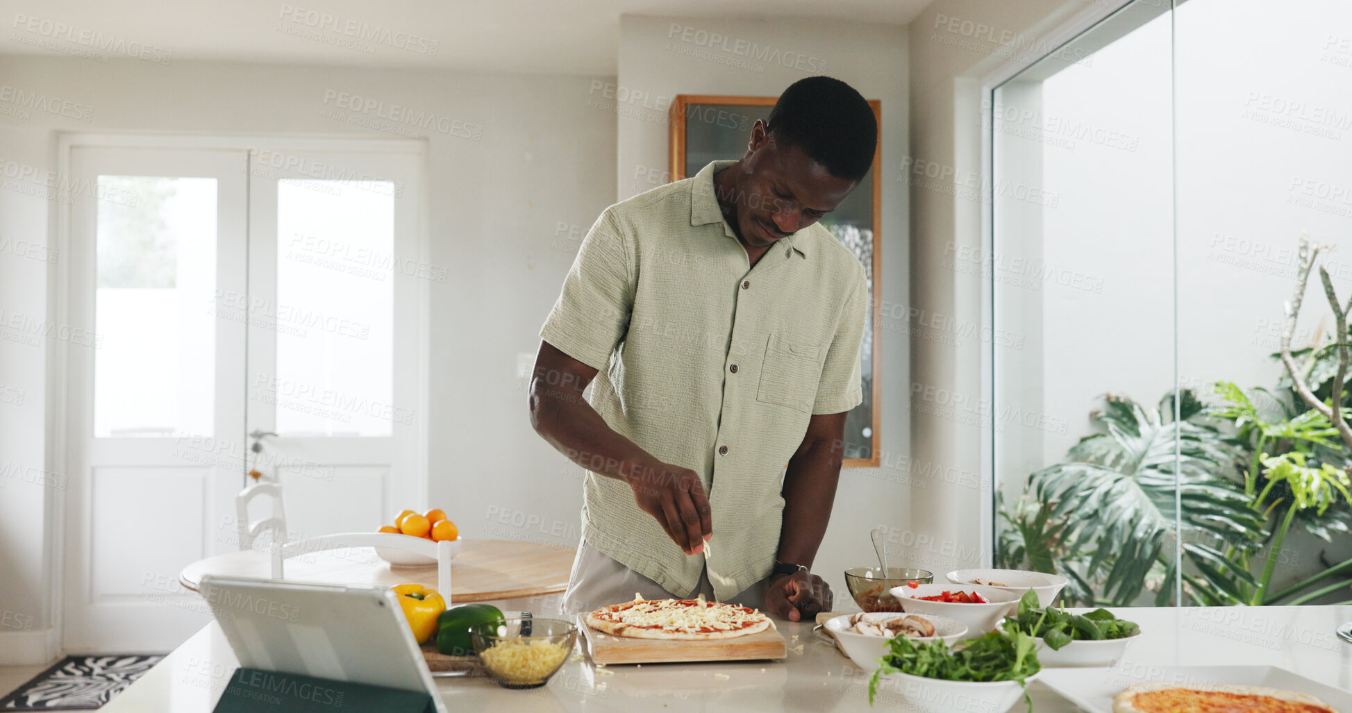 Buy stock photo Black man, tablet and cooking pizza in kitchen for online recipe, meal prep and organic ingredients. Chef, digital and cheese for Italian cuisine, steps and culinary skills of homemade lunch in home