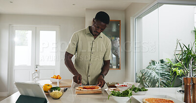 Buy stock photo Black man, tablet and cooking pizza at house with online recipe, meal prep and organic ingredients. Male person, digital and sauce for Italian cuisine, tutorial and culinary skills for homemade lunch