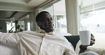 Buy stock photo Morning, thinking and black man on sofa with coffee, calm and reflection on weekend break. Smile, thoughts and male person in house with warm beverage, mindfulness and gratitude in Sunday routine.