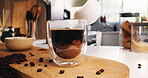 Coffee, glass and milk in kitchen for latte, strong caffeine or roast in home. Organic brew, drink and beans with cappuccino for mocha, espresso or breakfast beverage in house for morning preparation