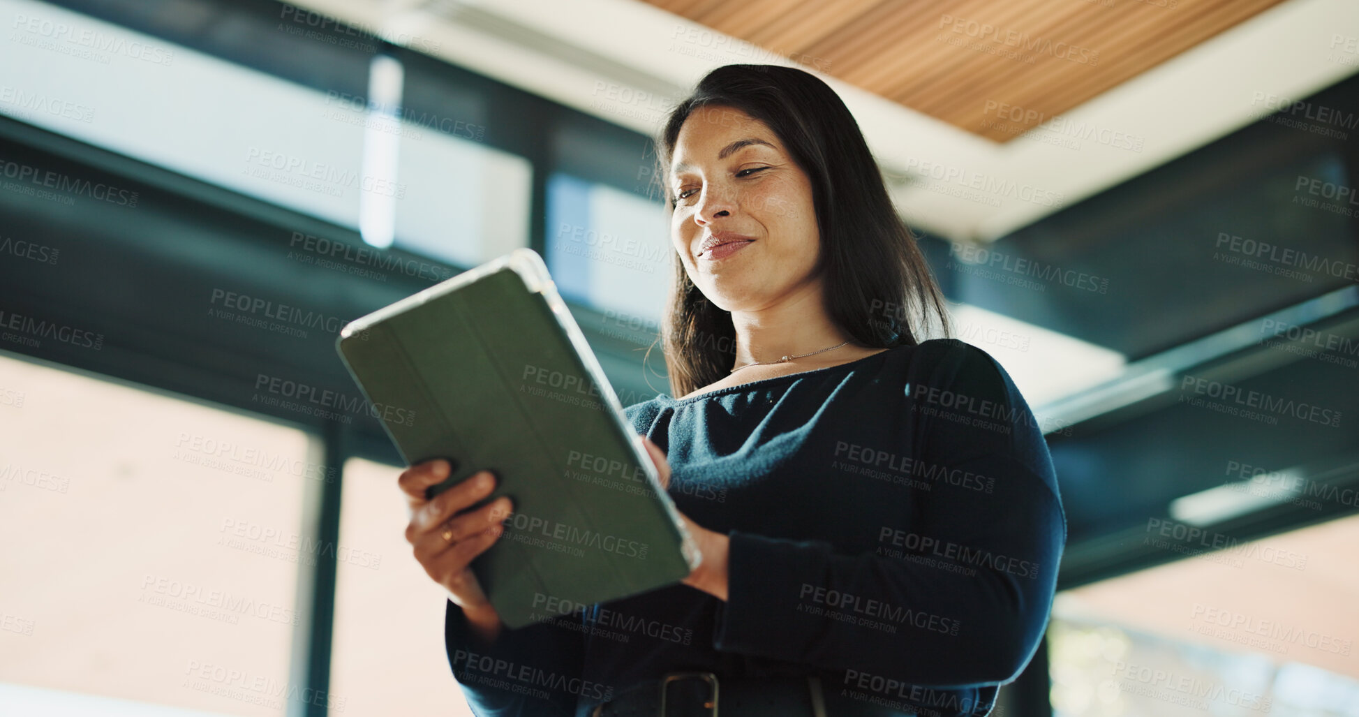 Buy stock photo Woman, realtor and tablet in office for reading, property management and service review. Low angle, estate agent and digital tech in agency for commission update, scroll and smile for research