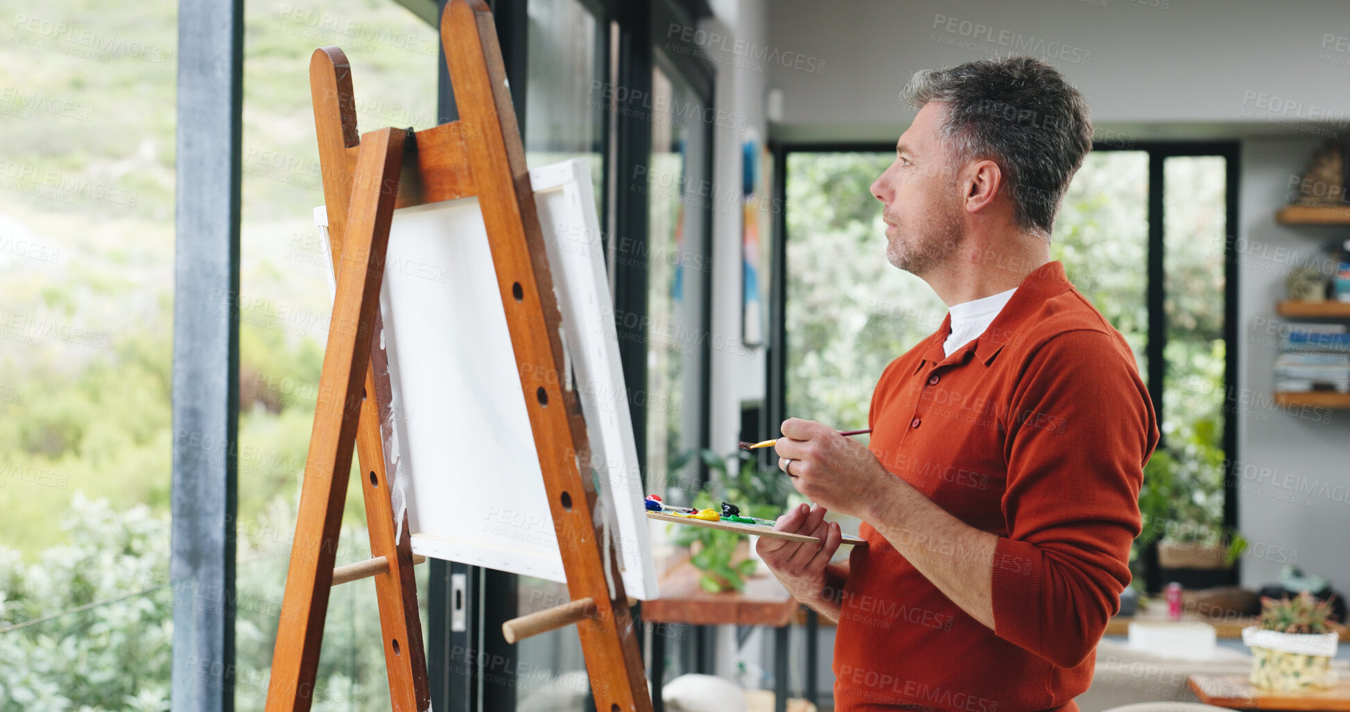 Buy stock photo Painter, think or canvas by window for creativity project, visual expression or inspiration for craft. Home, calm or mature man with brush for reflection, artistic activity or view landscape for idea