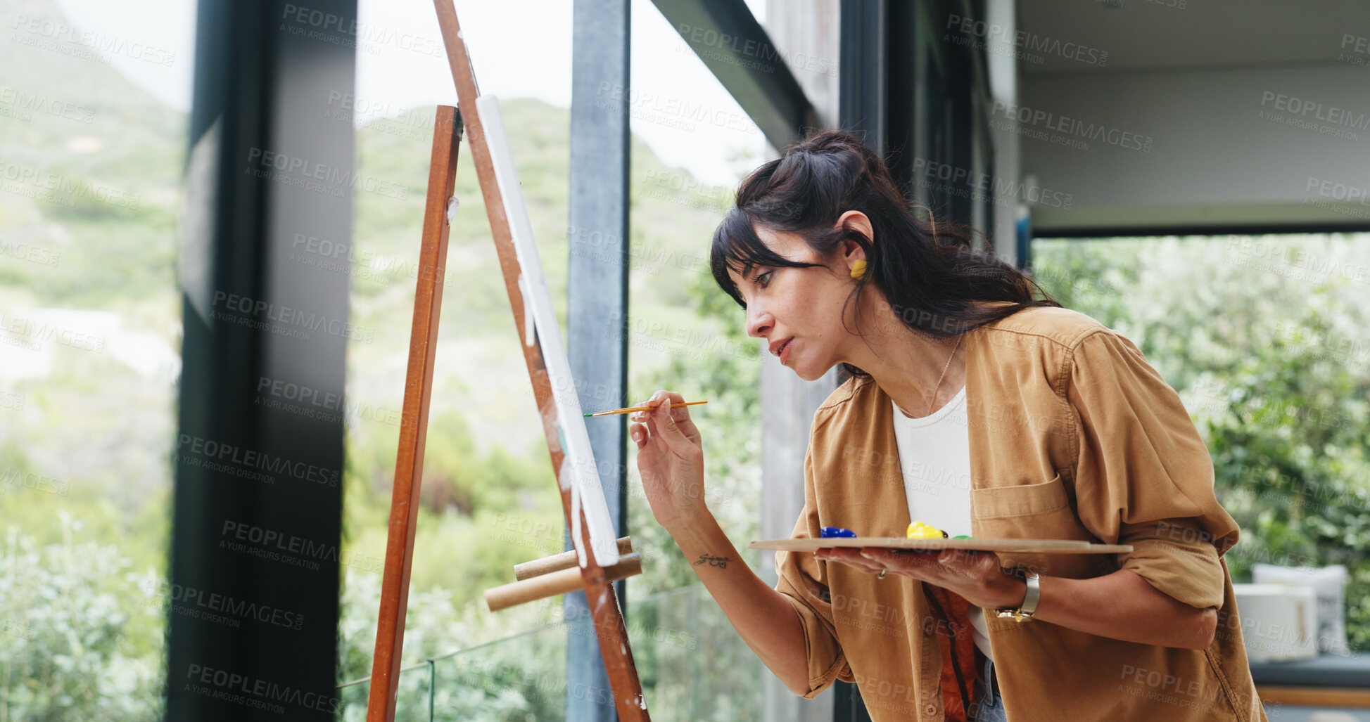 Buy stock photo Painter, woman or canvas by window for creativity project, visual expression or concentration for craft. Calm, freelancer or mature artist with brush for artistic activity, creation or talent in home