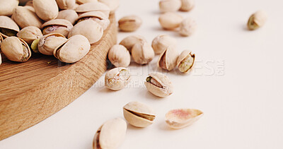 Buy stock photo Space, nuts and pistachios on table for diet, vegan meal and healthy snack for nutrition. White background, production and roasted seeds on wooden board for organic food, natural vitamins and protein