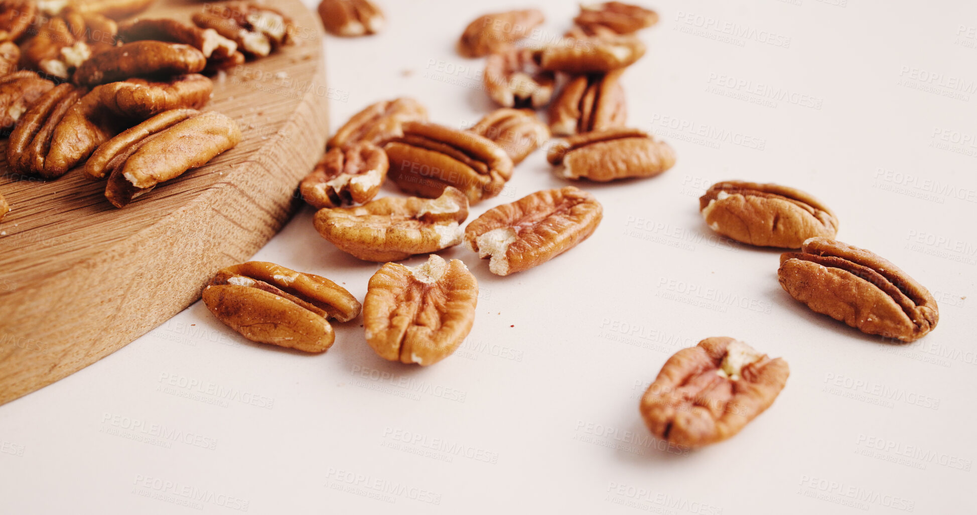 Buy stock photo Space, nuts and pecan on table for diet, vegan meal and healthy snack for nutrition. White background, production and roasted seeds on wooden board for organic food, natural vitamins and protein