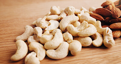 Buy stock photo Kitchen, nuts and cashews on table for diet, vegan snack and healthy food for nutrition. Empty, background and harvest of roasted almonds on wooden counter for organic fats, vitamins and protein