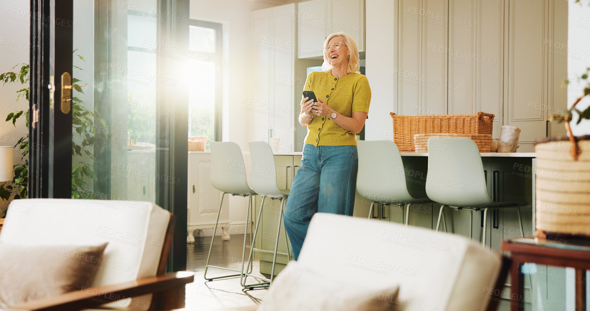 Buy stock photo Mature woman, phone and laugh in home with texting, meme or notification with funny gossip on lounge. Person, smartphone and happy with mobile app, contact or video on social network at apartment