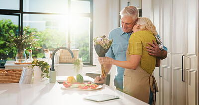 Buy stock photo Hug, flowers and cooking with old couple in kitchen of home for anniversary celebration, romance and gift. Love, present and bouquet with senior man and woman in house for date and meal prep