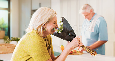 Buy stock photo Smell, flowers and woman or couple cooking in kitchen of home for anniversary celebration, romance or gift. Love, present or bouquet with senior man in house for floral scent and meal prep with smile