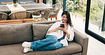 Smile, woman and relax with phone at house for social media, browsing website and texting contact. Person, resting and mobile to download game, online notification and chat for message update on sofa