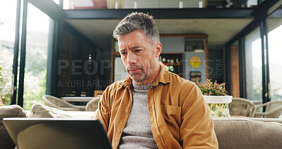 Buy stock photo Laptop, remote work and research with man on sofa in living room of home for online planning. Computer, email and typing with mature freelance employee in apartment for small business startup