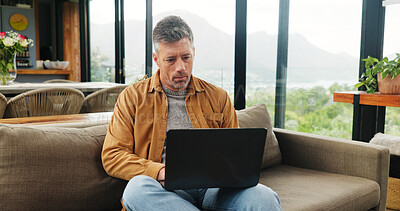 Buy stock photo Remote work, laptop and mature man in home for online article, website research and proofreading. Freelancer, living room and person on computer for editing report, story review and planning on sofa