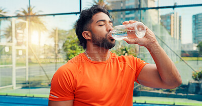 Buy stock photo Padel, drinking water and man with fitness, relax and training with break, hydration and aqua. Outdoor, person and tennis player with liquid, thirsty and practice with wellness, healthy and nutrition