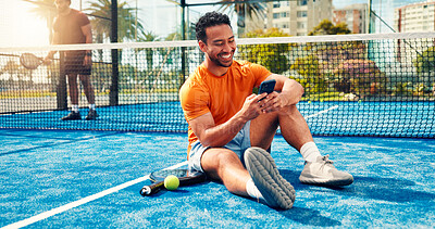 Buy stock photo Fitness, texting and man on tennis court with phone, match schedule and social media update on rest. Padel, smile and athlete outdoor with tech, wellness chat and virtual tutorial on training break.