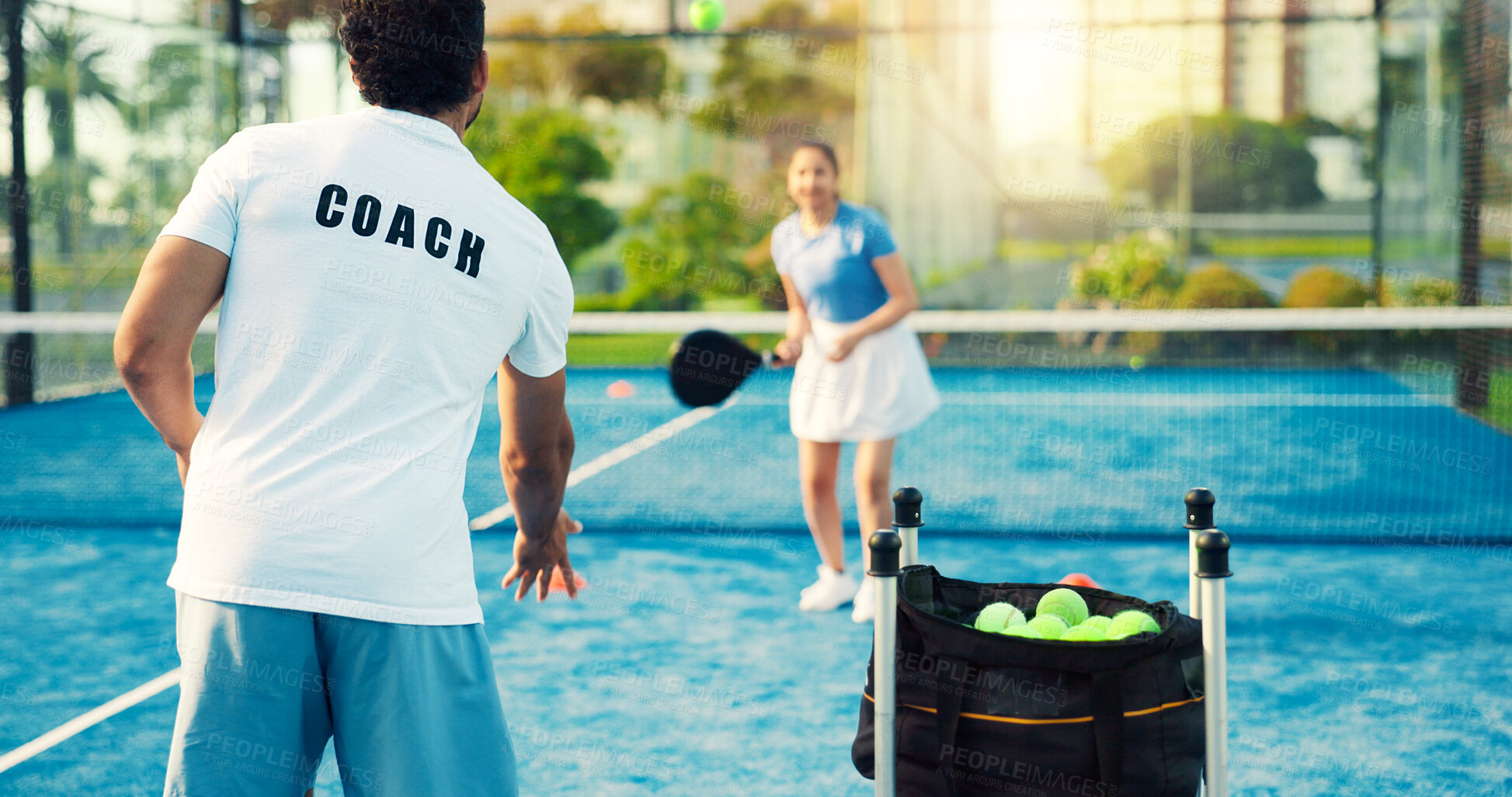 Buy stock photo Coach, woman and throw ball for padel training for coordination, power and exercise at sports club. People, mentor and athlete with racket, guide or fitness with back at tennis court for practice