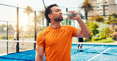 Buy stock photo Man, drinking water and fitness with padel, sports and hydration for wellness with exercise routine. Person, athlete and bottle for electrolytes, training or break at tennis court for game in city