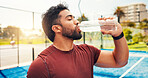 Man, drinking water and break for padel, sports and hydration for wellness with exercise routine. Person, athlete and bottle for electrolytes, training or fitness at tennis court for game in city