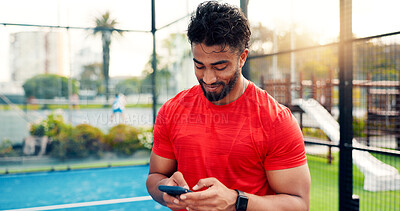 Buy stock photo Smile, man and reading with phone on tennis court with fitness app, training tips and track progress. Person, mobile and reservation for padel, technique and video demonstration of tournament results
