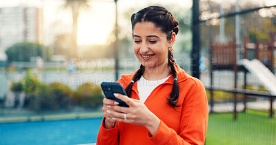Buy stock photo Smile, woman and reading with phone on tennis court with fitness app, training tips and track progress. Person, mobile and chatting for padel, technique and video demonstration of tournament match