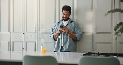 Buy stock photo Phone, smile and man in kitchen in home with networking, communication or social media on mobile app. Juice, technology and male person with cellphone for contact, texting or chatting in apartment.