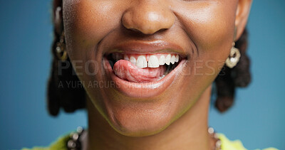 Buy stock photo Dental, lick and teeth with black woman in studio for hygiene results or oral care satisfaction. Dentistry, mouth and tongue with happy African person on blue background for cleaning or whitening