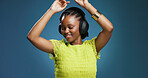 Headphones, dancing and black woman in studio with music, radio or song for rhythm and energy. Happy, audio tech and African person listening to album for groove entertainment by blue background.
