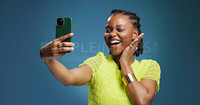 Buy stock photo Selfie, smile and social media with black woman in studio for profile picture or status update. App, excited and photograph with African content creator on blue background for streaming platform