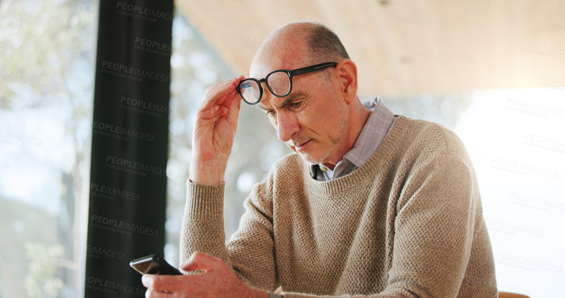 Buy stock photo Nursing home, glasses and senior man with smartphone, online and reading article with poor eyesight. Assisted living, eye strain and old person with wrong prescription eyewear, mobile and retirement